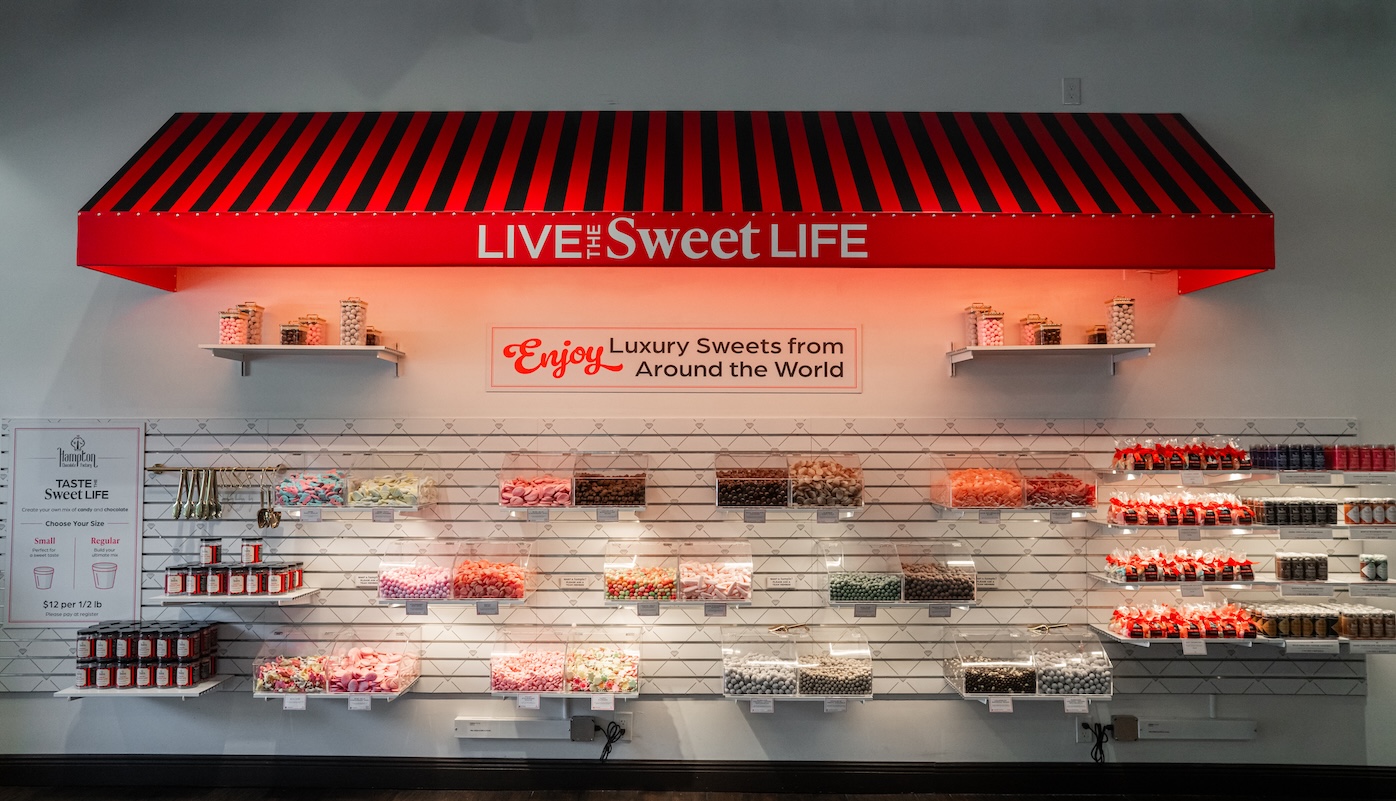 Colorful Swedish candy pick and mix display wall featuring various spring-themed gummies, marshmallows, and chocolates in clear bins.